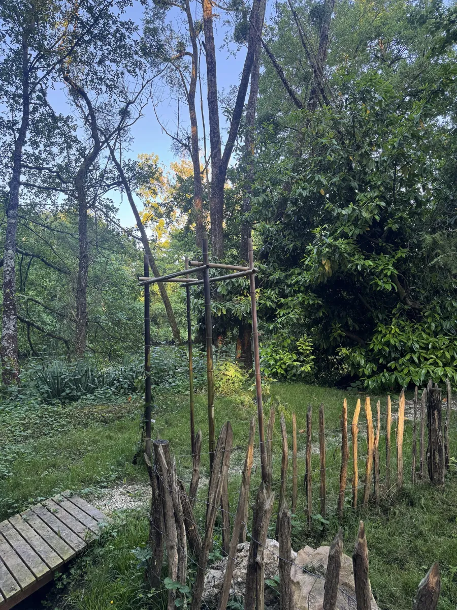 Ganivelle basse en châtaignier délimitant un coin de jardin, près d'un ponton en bois