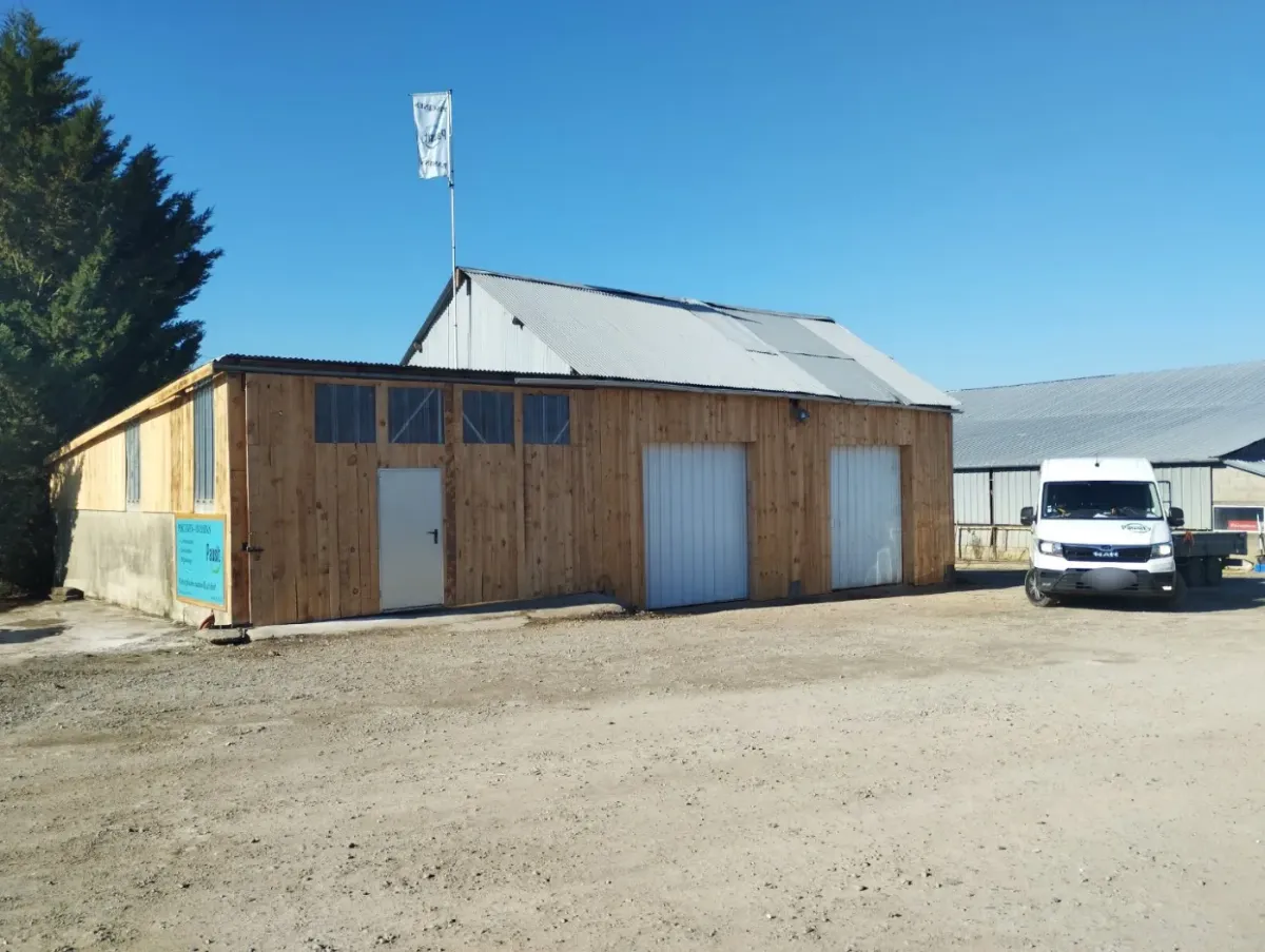 Bâtiment du dépôt Pausity habillé d'un bardage en lames de bois, sous un ciel dégagé