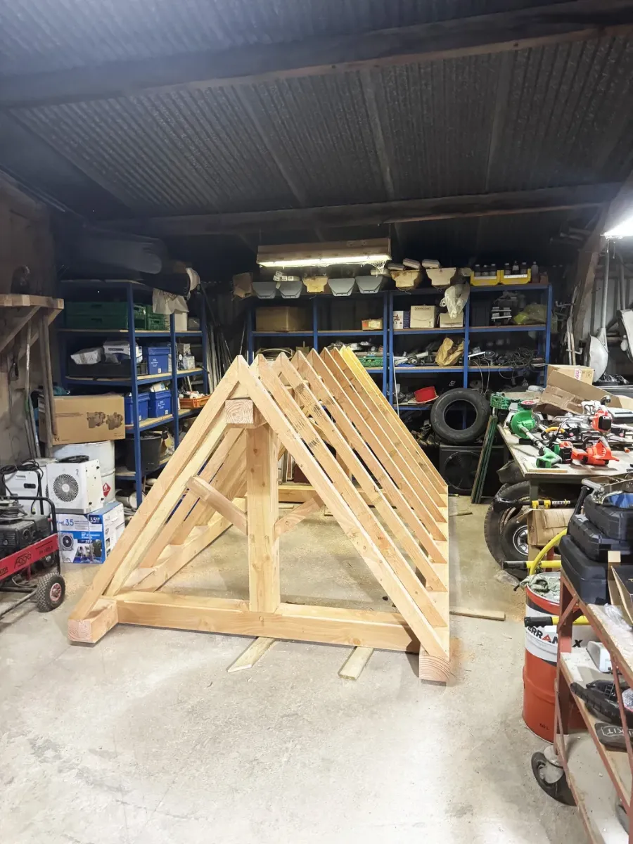 Ferme de charpente en bois assemblée à l'atelier, chevrons posés, avant transport sur le chantier