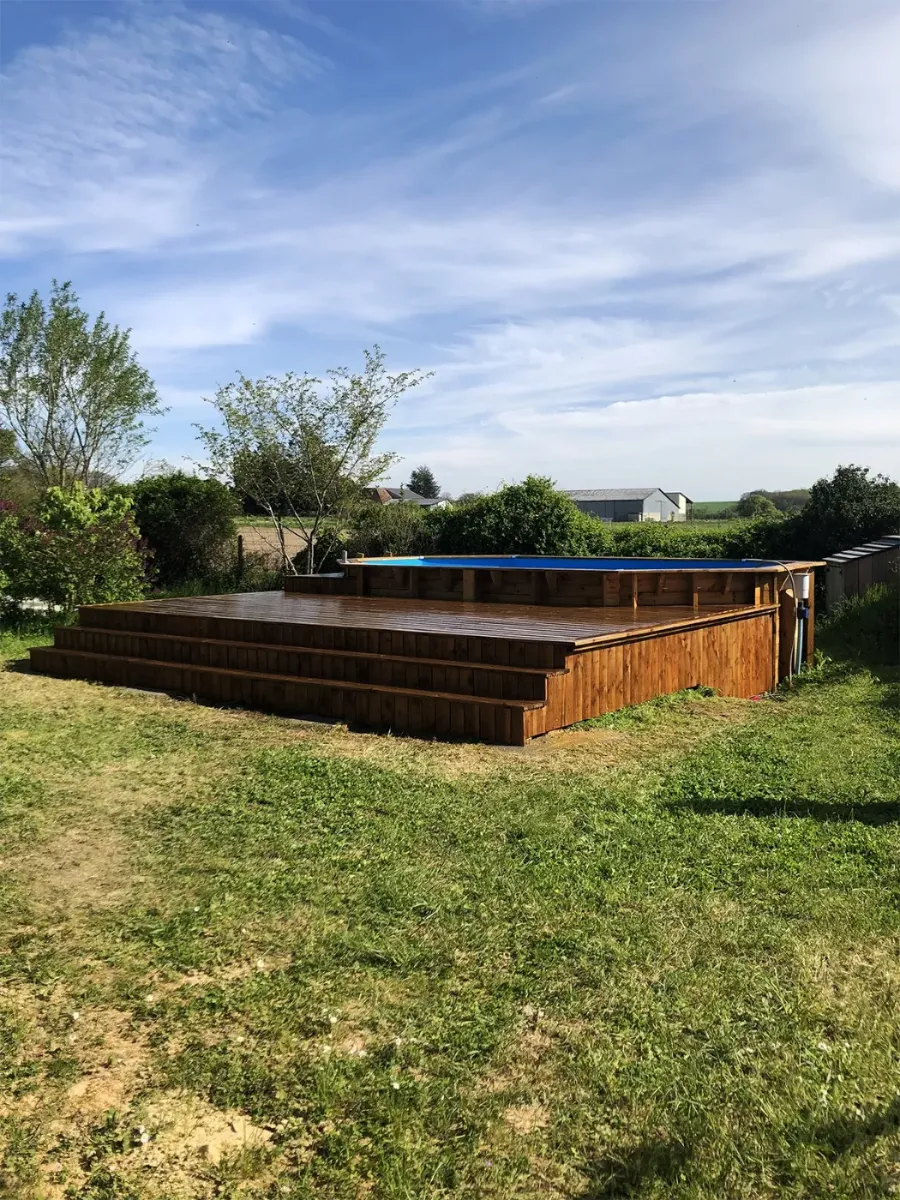 Terrasse en bois autour d'une piscine, avec volée de marches d'accès, ouverte sur la campagne