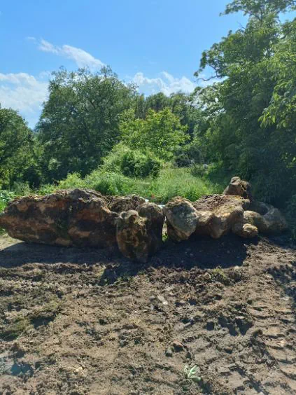 Ligne de blocs calcaires posés en limite de terrain, sol encore remué par le passage des engins