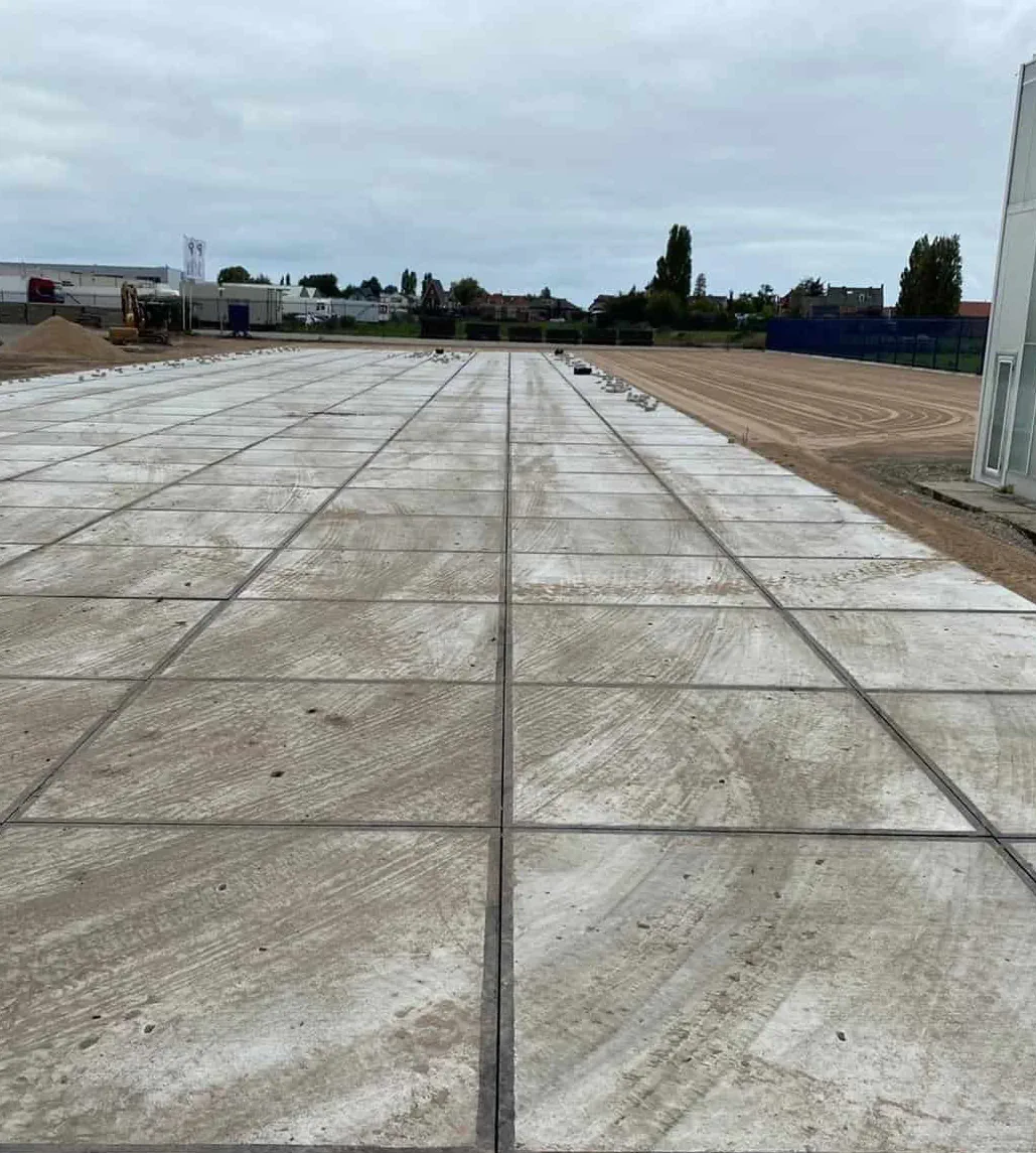 Vaste dalle de béton lissé coulée en bandes, en bordure d'une plateforme de sable
