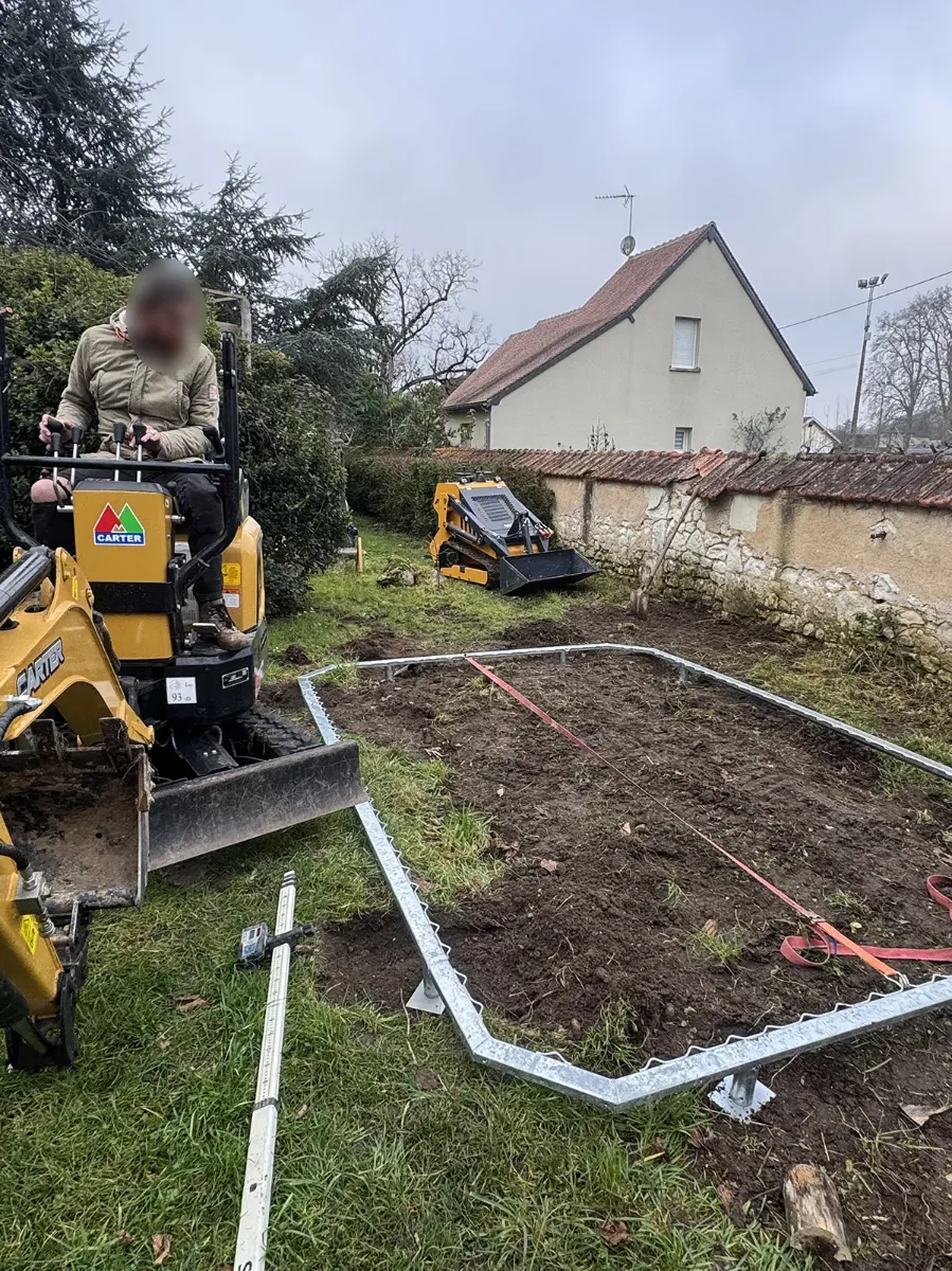 Châssis galvanisé d'un trampoline enterré positionné au cordeau, mini-pelle et chargeuse compacte sur le chantier